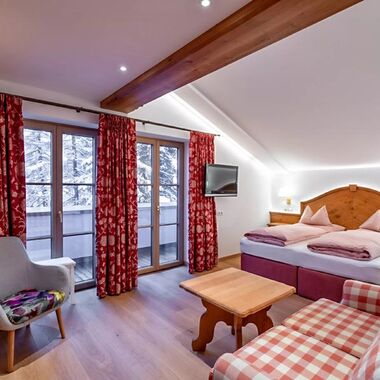 Das Schlafzimmer des Schneeprinzessin Zimmers, das geräumige Doppelbett und die hölzerne Einrichtung verbreiten einen ländlichen Charm