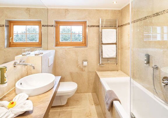 A bright bathroom with a bathtub, toilet and sink