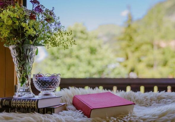 A stack of books and a bouquet of flowers on the balcony