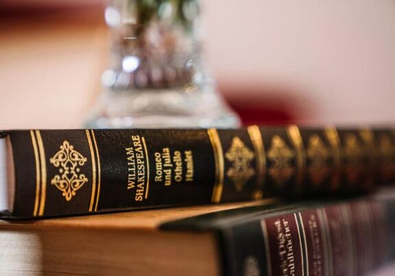 Zwei Bucher von William Shakespeare liegen auf den Nachtkasten.