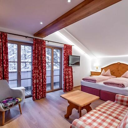 Das Schlafzimmer des Schneeprinzessin Zimmers, das geräumige Doppelbett und die hölzerne Einrichtung verbreiten einen ländlichen Charm