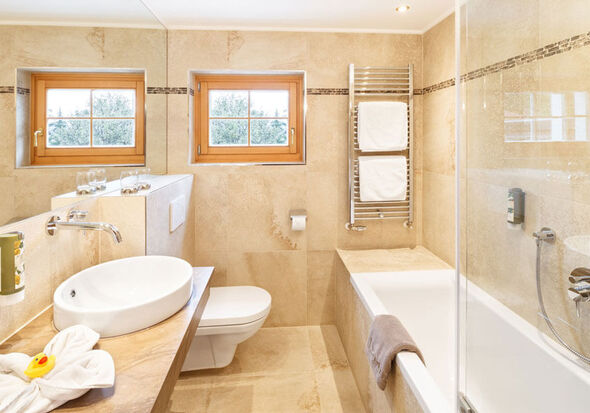 A bright bathroom with a bathtub, toilet and sink