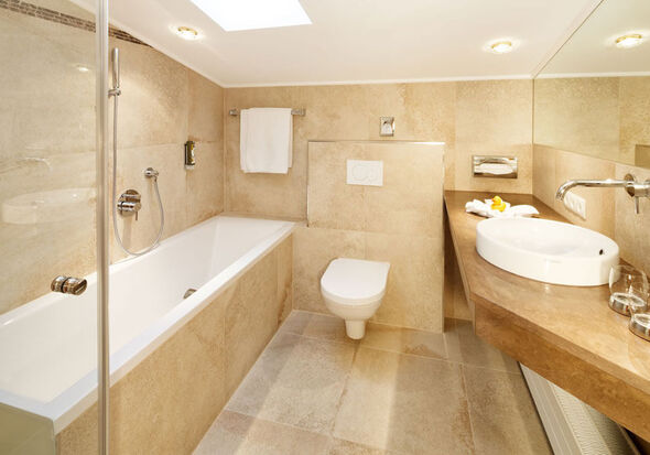 A bright bathroom with a bathtub, toilet and sink