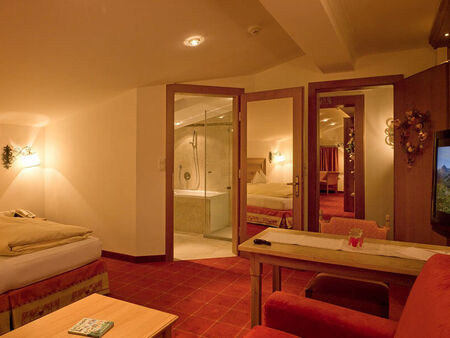 A large hotel room with bedroom bathroom and connecting doors