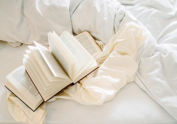 Three open books lie on the bed