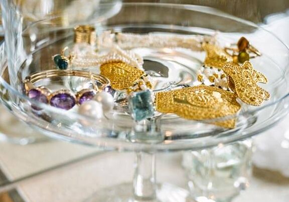 A glass tray filled with gold jewellery