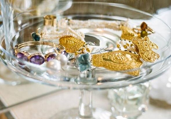 A glass tray filled with gold jewellery