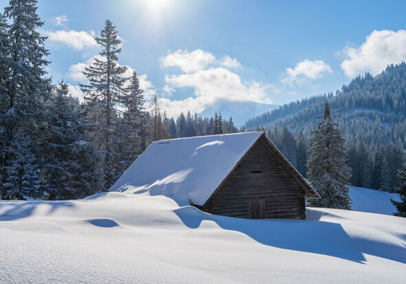 Eine Schneebedeckt Hütter in mitten der Berge
