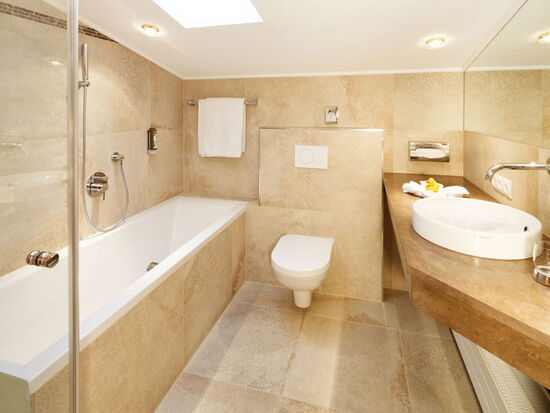 A bright bathroom with a bathtub, toilet and sink
