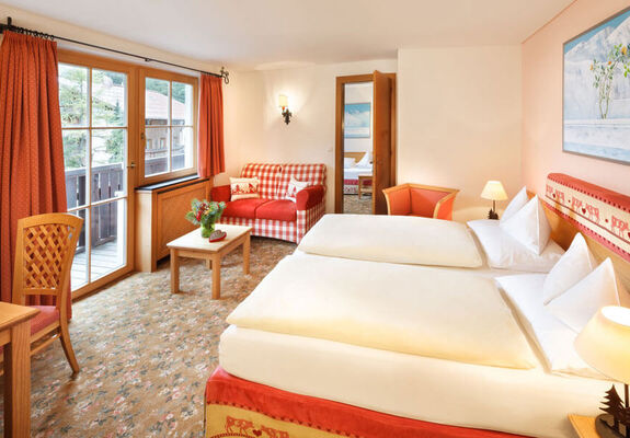 The double bed of the hotel room Snow Princess, with a view of the Alps from the window