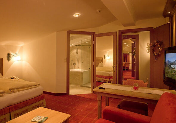 A large hotel room with bedroom bathroom and connecting doors