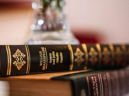 Zwei Bucher von William Shakespeare liegen auf den Nachtkasten.