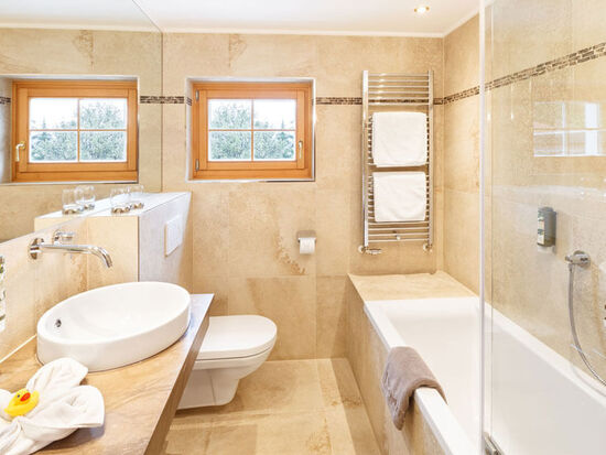 A bright bathroom with a bathtub, toilet and sink