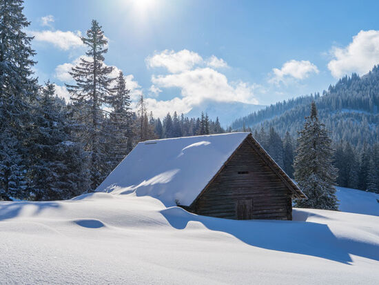 Eine Schneebedeckt Hütter in mitten der Berge