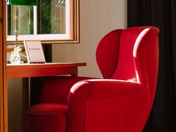 A red chair at the window
