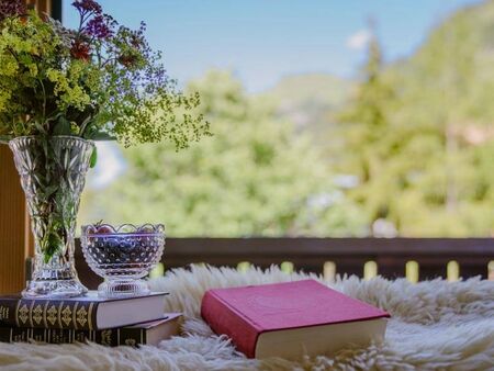 A stack of books and a bouquet of flowers on the balcony