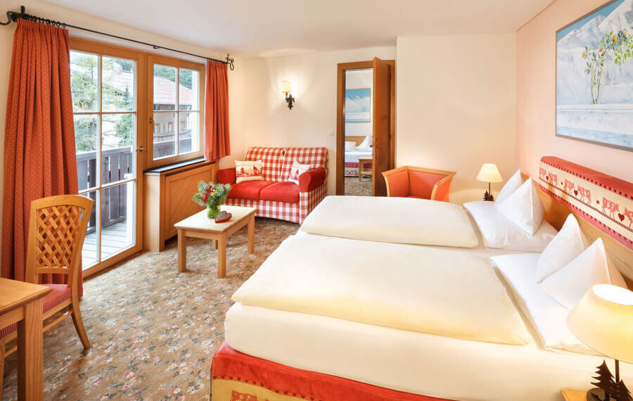 Das Doppeltbett des Hotelzimmers Schneeprinzessin, mit Blick aus dem Fenster auf die Alpen