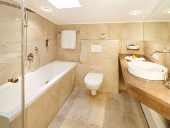 A bright bathroom with a bathtub, toilet and sink