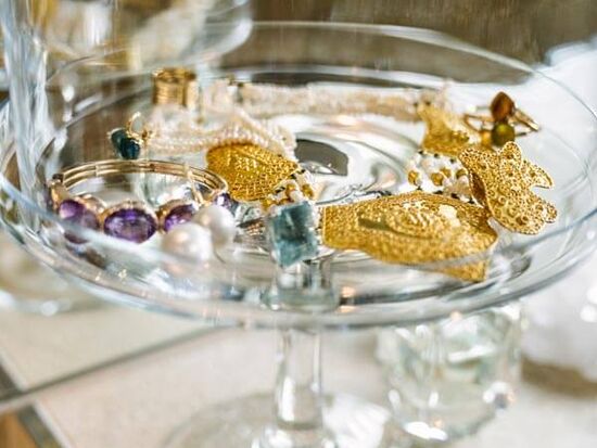 A glass tray filled with gold jewellery