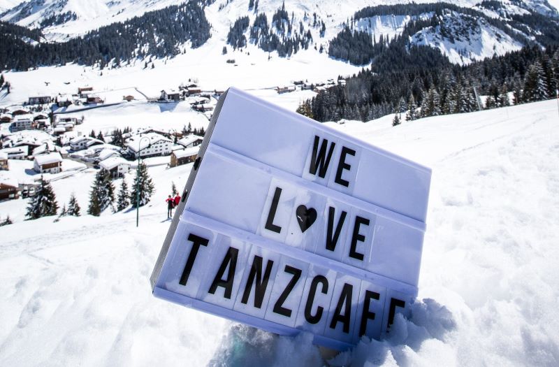 Schild im Schnee steckend mit der Aufschrift "We love Tanzcafé"